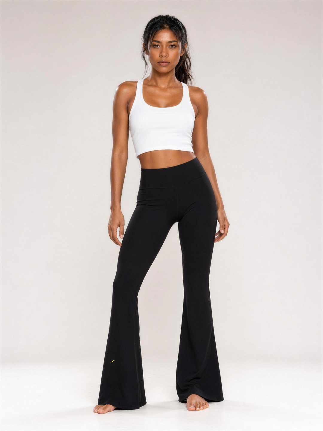 Woman wearing HIVOLT High-Waisted Flare Leggings, studio shot